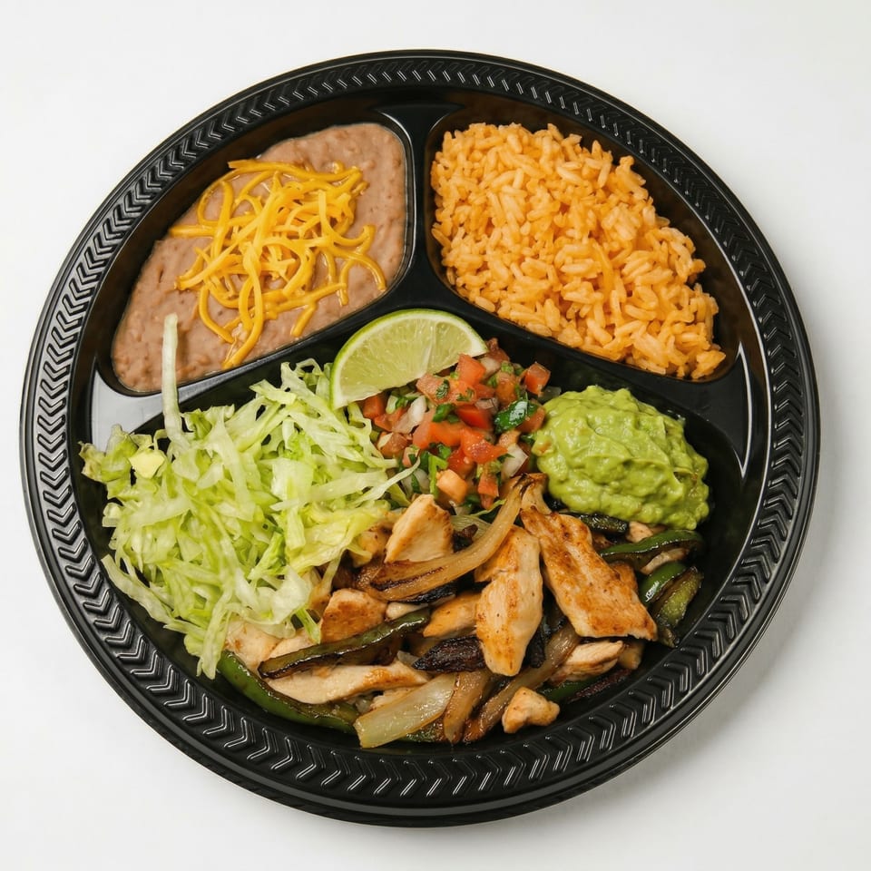 Chicken fajita platter with rice, beans, guacamole, pico de gallo, and shredded lettuce.